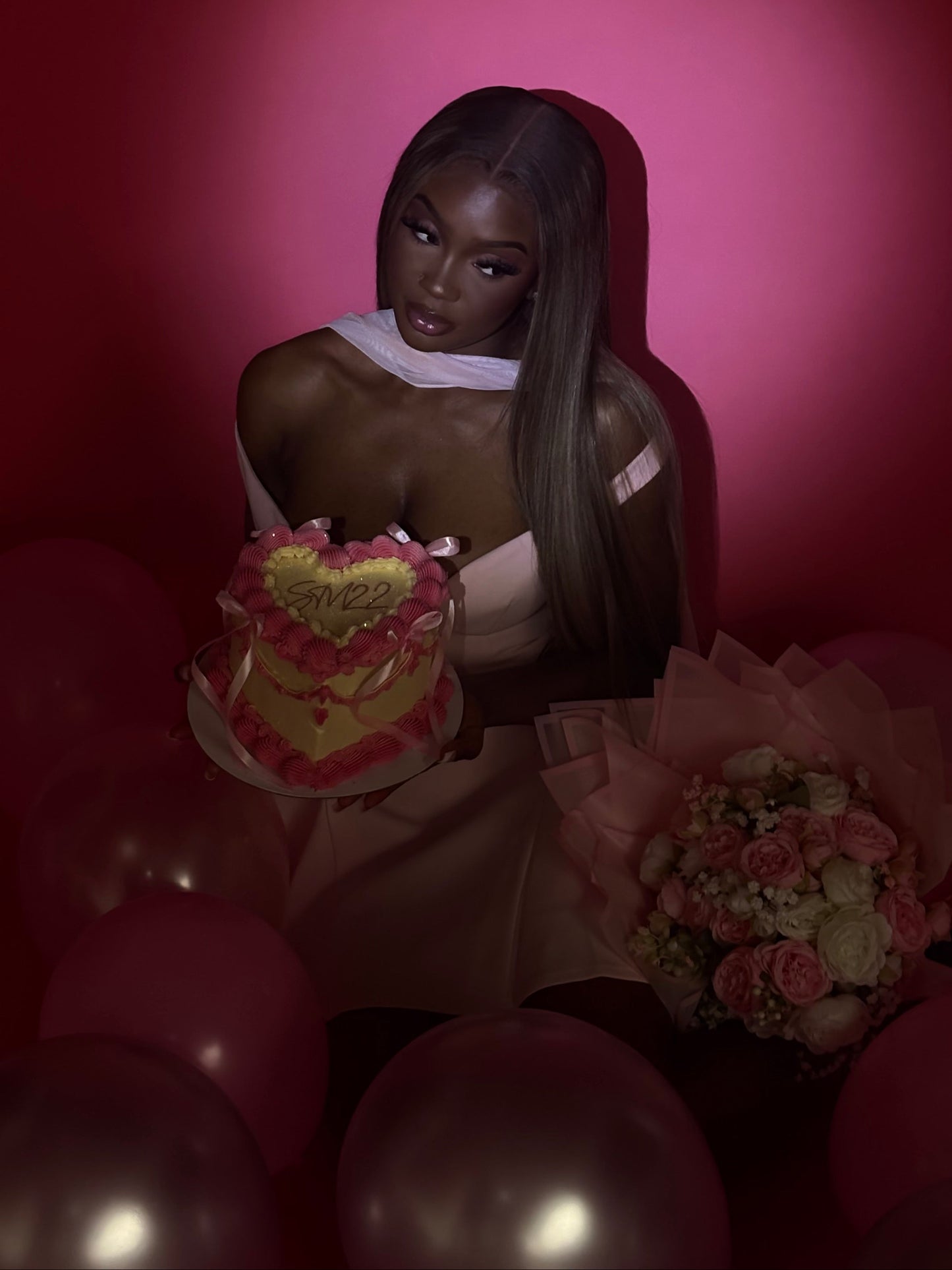 Woman holding a bouquet of flowers with balloons in the foreground